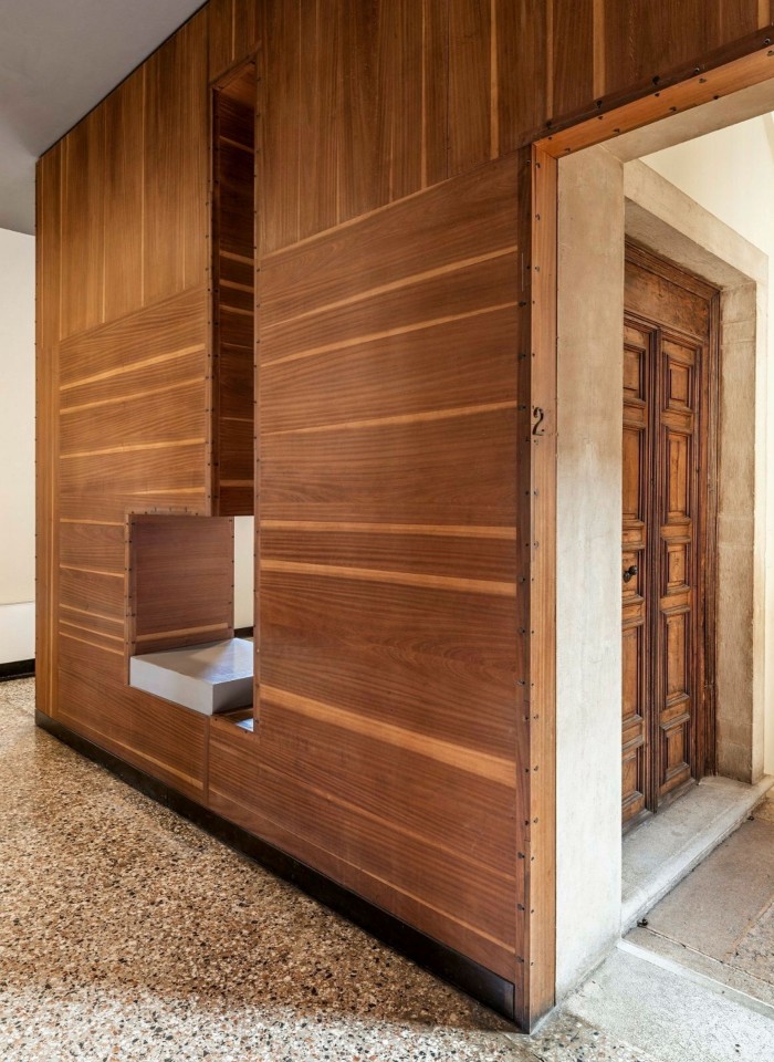 A wooden wall with a hatch-type square hole in it in a room in the Museo Correr