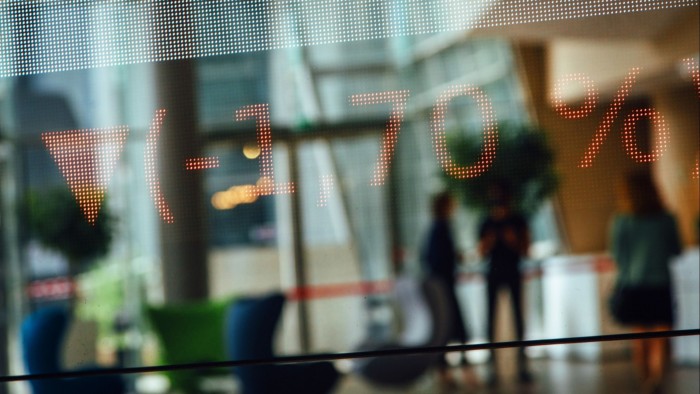 Trading price movements displayed on a glass panel in the lobby of the Euronext Paris stock exchange