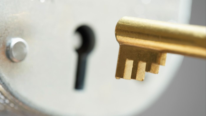 A close-up view of a brass key positioned near a keyhole